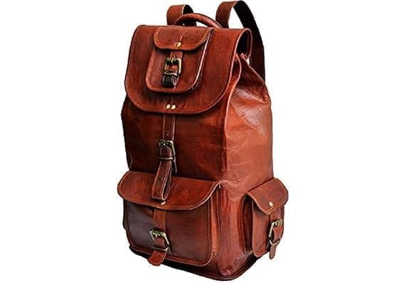 A vintage brown leather unisex backpack with multiple compartments and brass buckles.