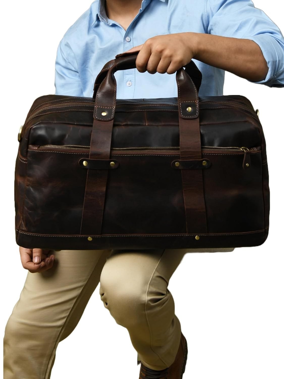 A person holding a brown leather travel duffle bag with dual handles.